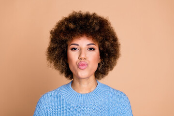 Photo portrait of young funky american lady with brown hair chevelure in blue knitted sweater pouted lips kisses isolated on beige color background