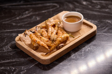 Delicious Grilled Shrimp Accompanied by a Sauce on a Rustic Wooden Platter for Serving