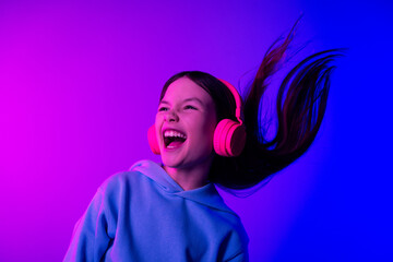 Photo of adorable lovely small girl wear hoodie earphones singing empty space isolated magenta blue color background