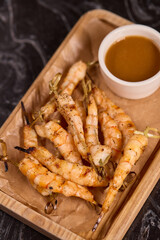 Delicious Grilled Shrimp Accompanied by a Sauce on a Rustic Wooden Platter for Serving