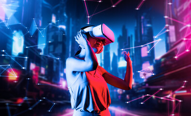 Female standing in virtual reality cyberpunk style building wear VR headset connecting metaverse, future cyberspace community technology, Woman dancing raising one arm holding goggle. Hallucination.