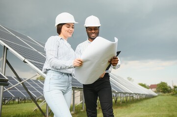 Team of young engineers on a solar farm