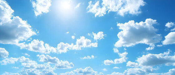 Bright blue sky with fluffy white clouds and sun shining through.