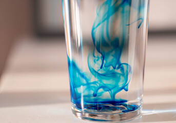 abstract closeup image of methylene blue in a glass of water.
