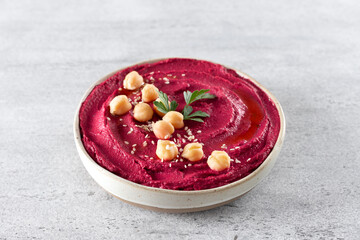 Beetroot hummus with parsley and olive oil in a plate on a gray background, top view. Arabic, Turkish cuisine.