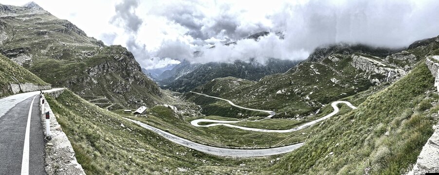 Panorama photo with HDR effect of winding pass road to Alpine pass Colle del Col de Nivolet, low clouds in the background, Gran Paradiso National Park, Ceresole Reale, Piedmont, Italy, Europe