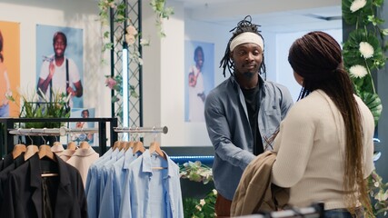African american man in fancy fashion boutique trying on ideal stylish formal clothes for him to...