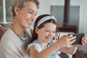 Selfie, happy and grandmother with child in home for bonding, connection and family time. Smile, love and girl kid with senior woman for photography picture together in living room at house in Canada