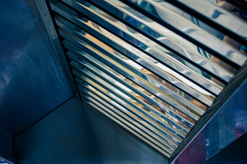 Stainless steel exhaust hood with grease trap close-up in a large industrial kitchen in the...