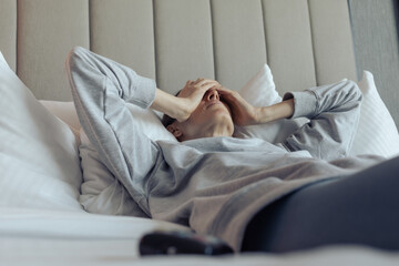 Young woman lying in her bed feeling tired stressed exhausted 