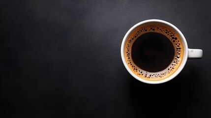 Overhead shot of a coffee cup with deep black coffee, positioned on a black surface, wide copy space, precise studio lighting emphasizing details.