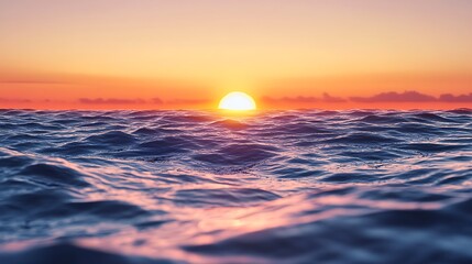 Obraz premium A vibrant sunset over the ocean, the sun setting below the horizon, casting a warm glow on the water.