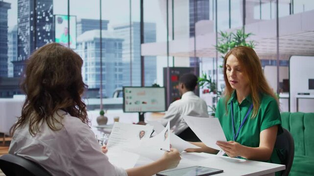 Human resources staff evaluating candidates resume in the selection process, reviewing all applicants after job interview in order to hire the right person. Recruiters seeking personnel. Camera B.