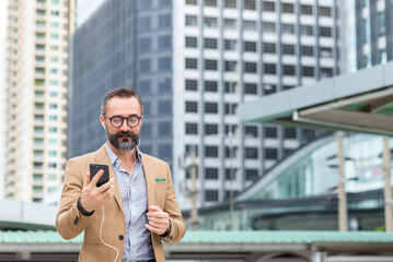 Confidence Caucasian businessman working on smartphone during walking city street. Professional male executive using technology working corporate business financial and communication in the city.