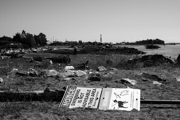 a vandalized sign on the beach in black and white