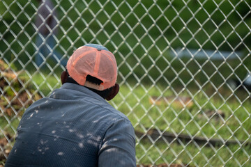 worker waits behind a security fence