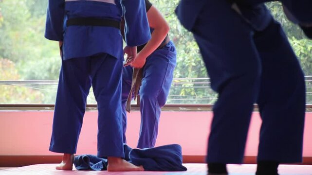 Judo fighter portrait sitting and resting in dojo with some trees at background