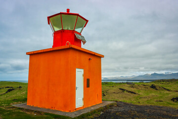 Small Orange Lighthouse nestled in the Icelandic Hills