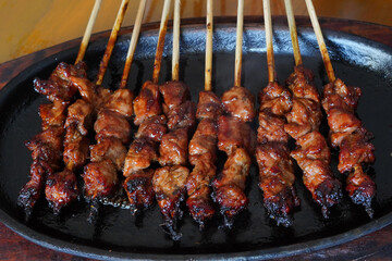 a plate of grilled satay skewers.