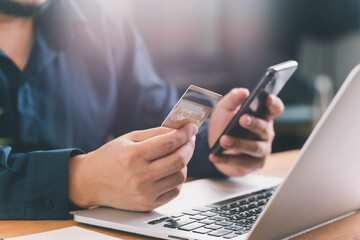 Close up Male hands holding credit card and smartphone, man paying online, credit card shopping, using banking service, entering information, shopping, ordering in internet store, doing secure payment