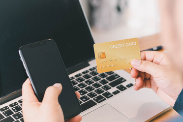 Close up Male hands holding credit card and smartphone, man paying online, credit card shopping, using banking service, entering information, shopping, ordering in internet store, doing secure payment