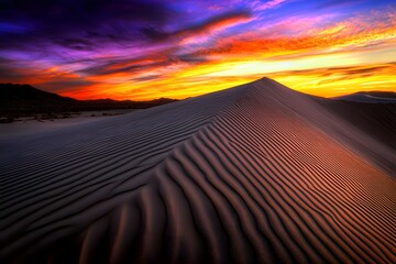 Naklejka premium Majestic desert sand dune bathed in warm hues of sunset, showcasing the intricate patterns of shifting sands under a vibrant sky.