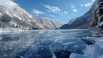 Pristine frozen lake reflects the majestic snowy mountains and clear blue sky, creating a serene and captivating winter wonderland