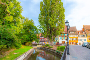 One of the many canals of the Lauch River in the Petite Venise district, seen from the historic and colorful Rue des Tanneurs street in Colmar, France.