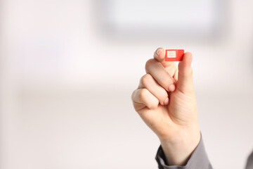 Woman holding SIM card indoors, closeup. Space for text