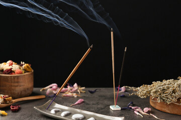 Aromatic incense sticks smoldering on grey table