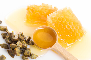 Sweet honeycombs and propolis granules on white background