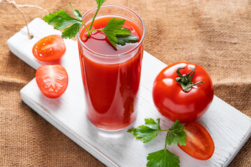 Dietary tomato juice on a linen background. Healthy drink made from farm vegetables.