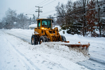 Heavy construction equipment clearing snow on MacArthur Boulevard near Washington, DC, during the...
