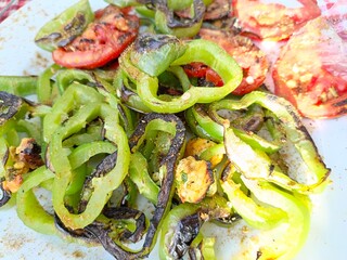 Ben Smim, Morocco - August 08, 2024: Tomatoes and peppers ready to grill on charcoal, for a delicious grilled meal