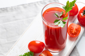 Refreshing tomato juice with parsley on a white background. Vegan vegetable smoothie.