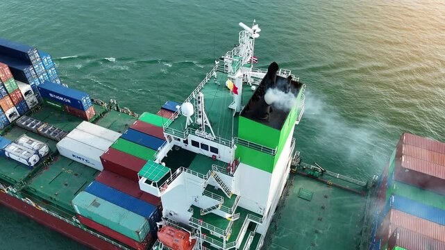 Emissions contaminate of Smoke exhaust carbon dioxide Cargo Container ship at sunset. Incomplete combustion pollution exhaust vapour of large Container ship Resulting in environmental destruction.