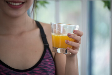 Asian women smile laugh look at camera health care home fitness lifestyle. Women hands holding cold orange juice fresh fruit cool drinking. Beautiful female pouring orange juice from cocktail bottle