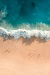 High angle aerial photography of huge waves and people on the kelingking beach in Penida, Bali, Indonesia