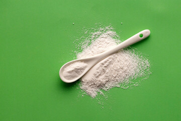 Baking Soda - Crystalline Solid compound in spoon. Green background