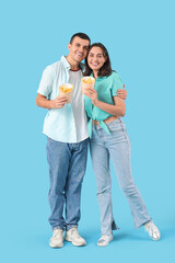 Fototapeta premium Young couple with french fries on blue background