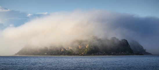 a cloud of fog and mist over lion island on nsw central coast australia