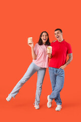 Young couple with french fries on orange background