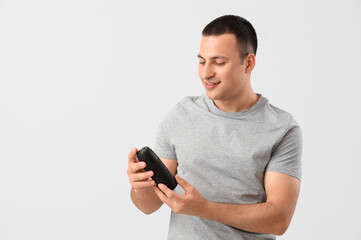 Handsome young man with deodorant on grey background