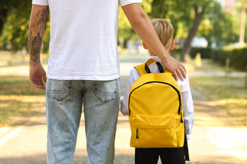 Father walking his little son to school