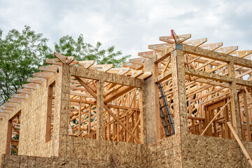 New residential home construction in framing stage, looking up at second floor with OSB, oriented...