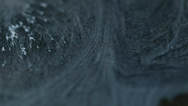 Ink glitter. Defocused fluid. Liquid gray paint art. Black mixed white particles texture emulsion flows acryl shiny waves background.