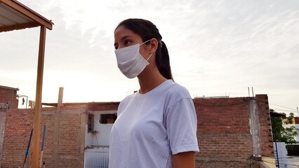 Young woman with a mask for protection against coronavirus COVID-19 on a sunny day