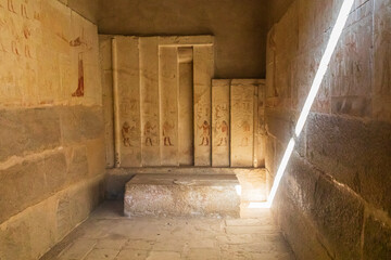 Africa, Egypt, Saqqara. October 4, 2018. Shaft of light illuminating the interior of a temple with hieroglyphs at the Saqqara Necropolis.