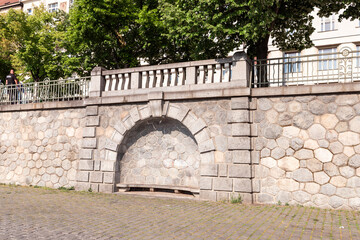 Stone bench in niche on embankment in old part of city near Visegrad district in Prague in Czech Republic