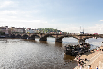 Pedestrian embankment and Palacky Bridge on the Vltava River in Prague in Czech Republic